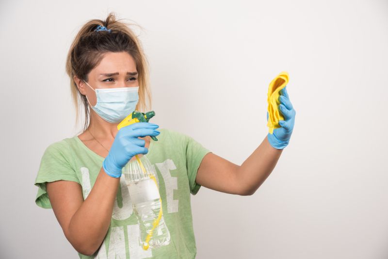 Young woman with facemask spraying