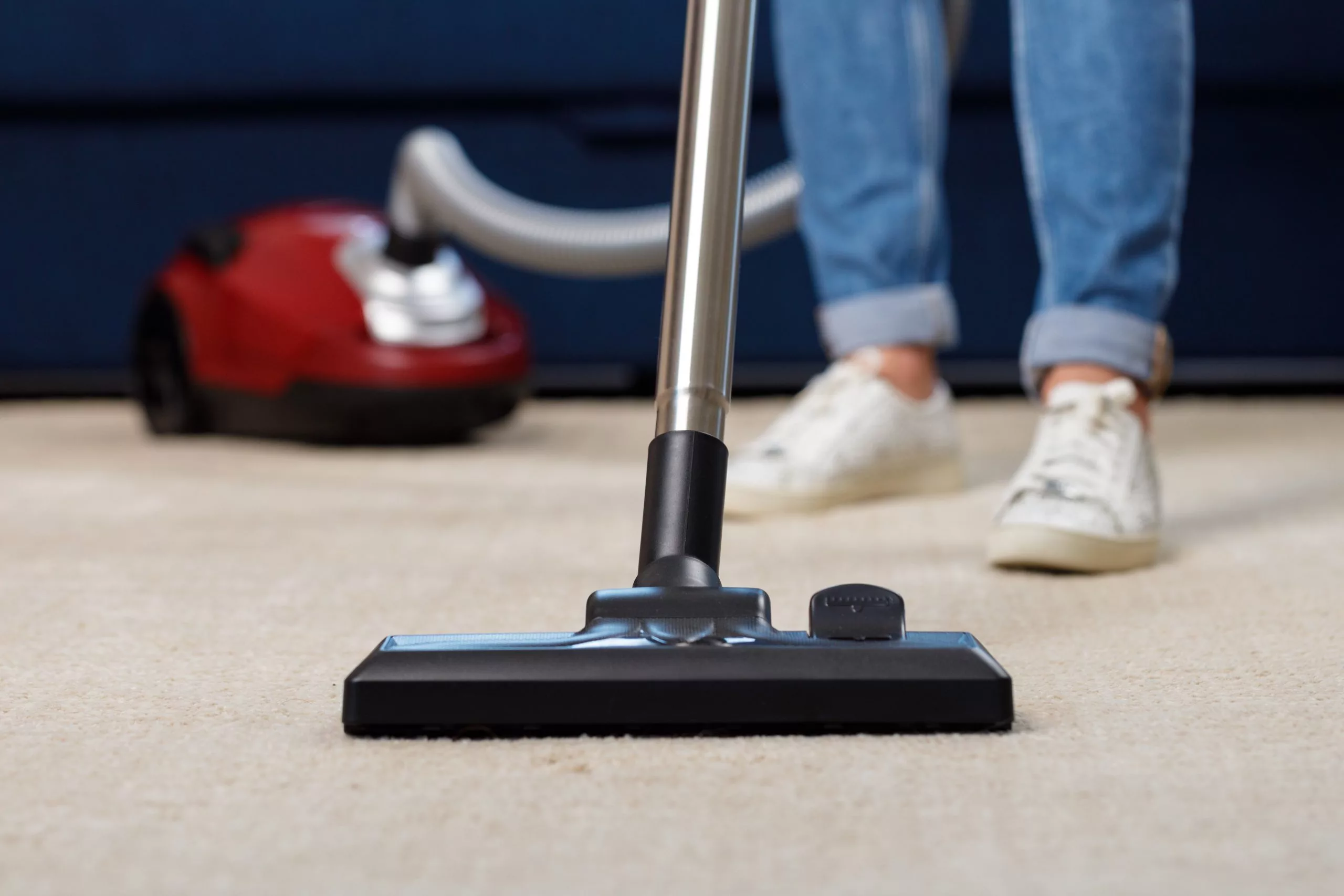 close-up-of-a-woman-vacuum-cleaning-the-carpet-376J458-scaled.jpg